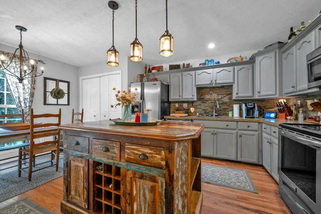 a kitchen with stainless steel appliances granite countertop a stove and cabinets