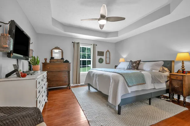 a bedroom with a bed a dresser and a flat screen tv