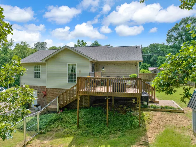 a front view of a house with a garden and trees