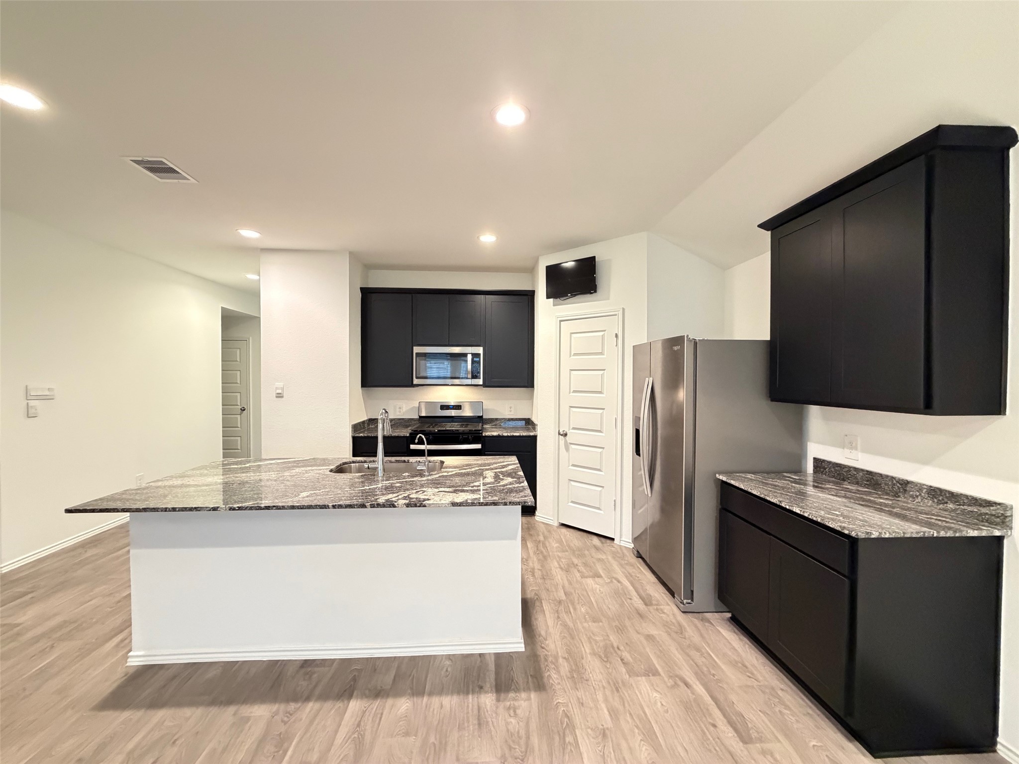 2913 Willow Gulch Way Rosenberg, TX 77469 - Photo 6 of 16 a large kitchen with stainless steel appliances a refrigerator a stove a sink a center island and furniture