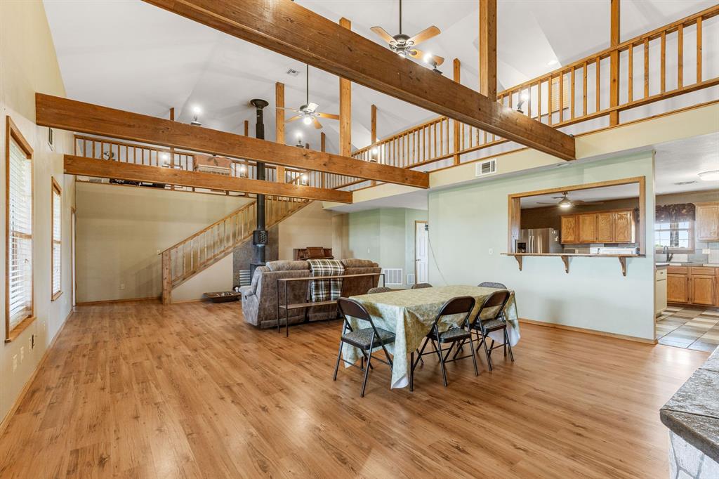 13315 Highway 281 Scotland, TX 76379 - Photo 5 of 40 Vaulted ceilings with exposed wood beams, parquet flooring, and a second-story balcony overlook