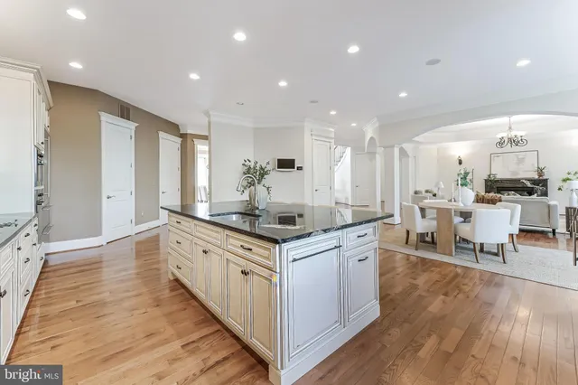 a spacious bathroom with a granite countertop double vanity sink a mirror and a bathtub