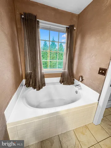 a bath tub sitting in a bathroom next to a window