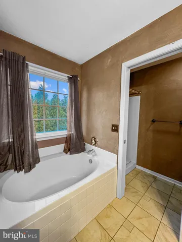 a bath tub sitting in a bathroom next to a window