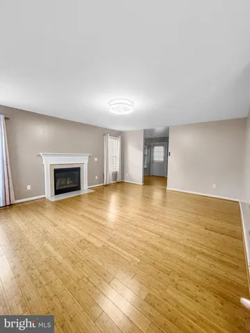 a view of empty room with wooden floor and fireplace