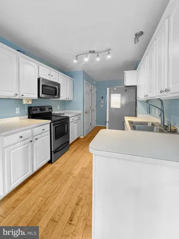 a large kitchen with stainless steel appliances granite countertop a stove sink and cabinets