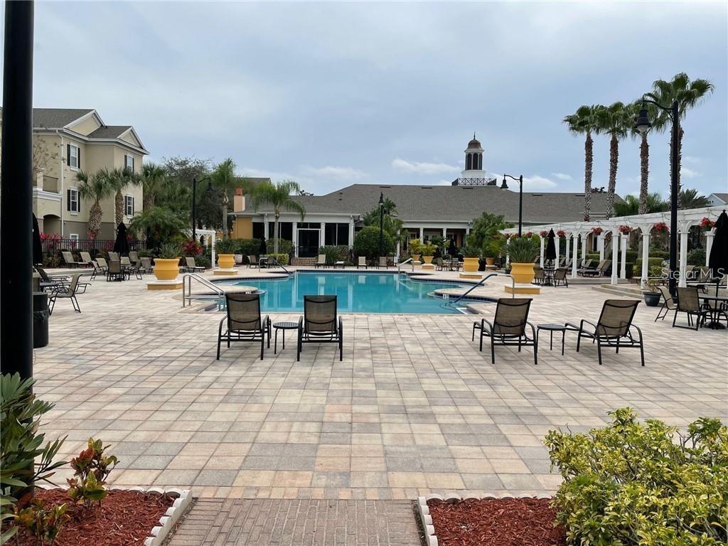 3611 Conroy Road, Unit 825 Orlando, FL 32839 - Photo 25 of 27 a view of a patio with dining table and chairs with plants and palm trees