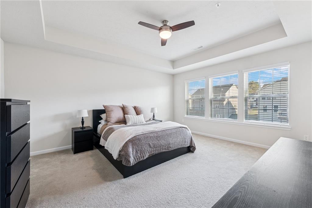 204 Eagle Drive Cranberry Township, PA 16066 - Photo 19 of 34 a spacious bedroom with a bed a large window and a flat screen tv