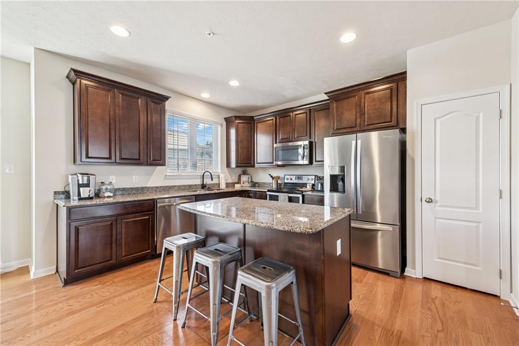 204 Eagle Drive Cranberry Township, PA 16066 - Photo 7 of 34 a kitchen with stainless steel appliances granite countertop a refrigerator a stove top oven a sink dishwasher and wooden cabinets with wooden floor