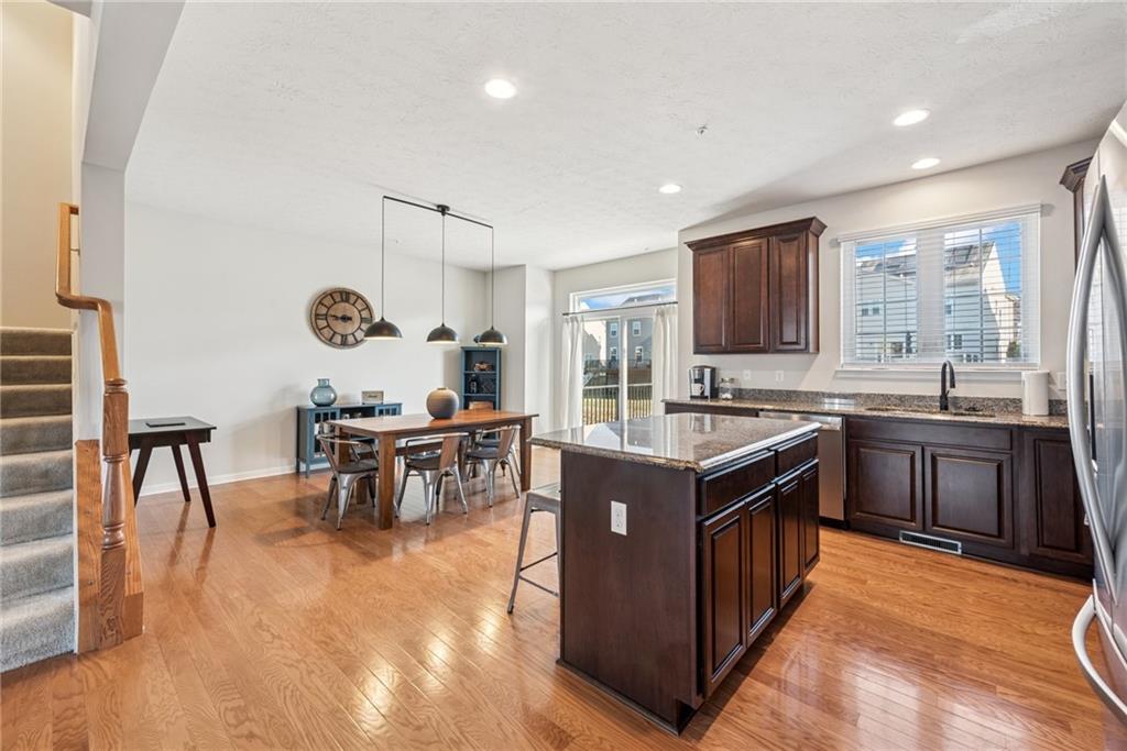 204 Eagle Drive Cranberry Township, PA 16066 - Photo 8 of 34 a kitchen with stainless steel appliances granite countertop a stove top oven a sink dishwasher a dining table and chairs with wooden floor