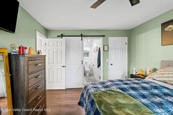 a bedroom with a bed and a flat tv screen
