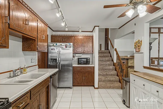 a kitchen with granite countertop a refrigerator a sink and dishwasher