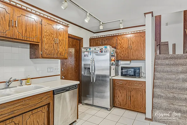 a kitchen with stainless steel appliances granite countertop a refrigerator and a sink