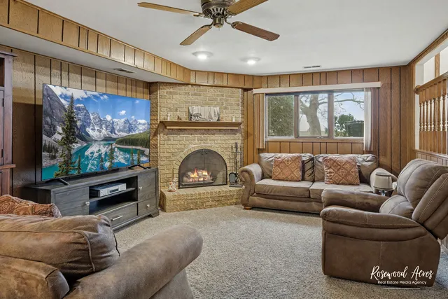 a living room with furniture a fireplace and a flat screen tv