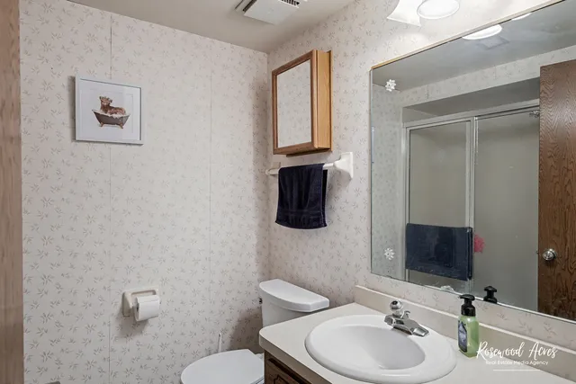 a bathroom with a toilet sink and mirror