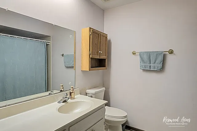 a bathroom with a sink mirror vanity and toilet