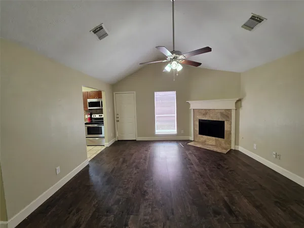 a view of an empty room with a fireplace and a window