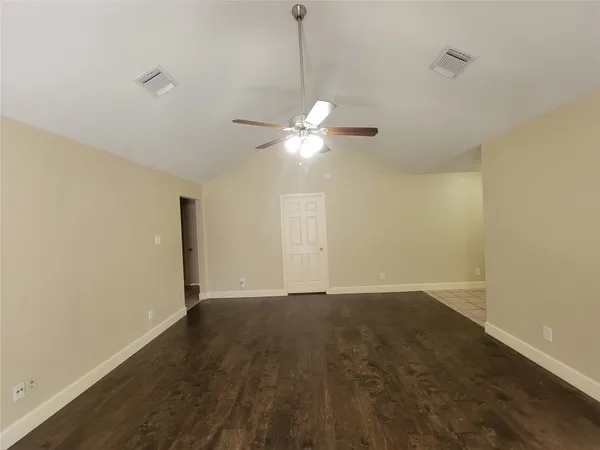 an empty room with a ceiling fan and a window