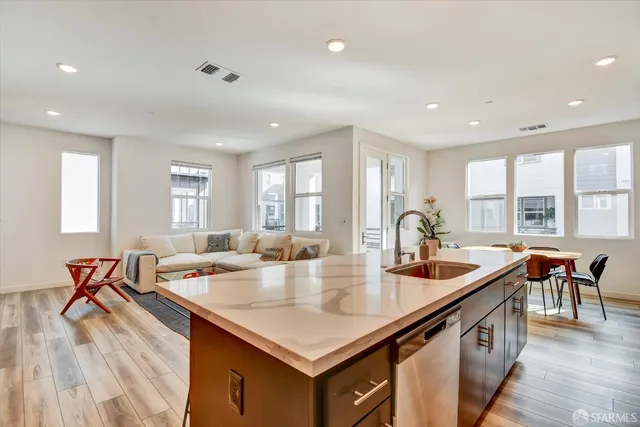 a open kitchen with stainless steel appliances granite countertop a sink and wooden floors