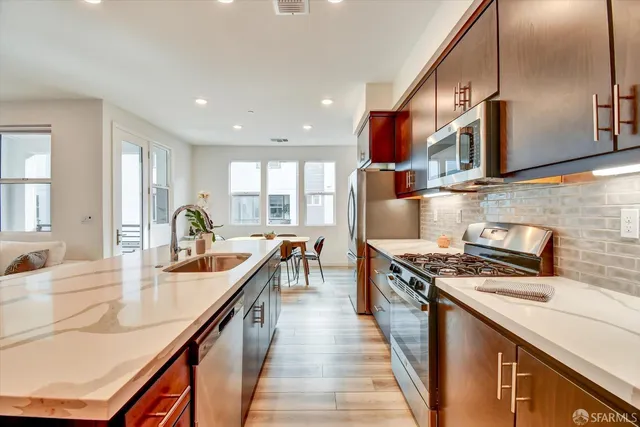 a kitchen with stainless steel appliances granite countertop a sink stove and refrigerator