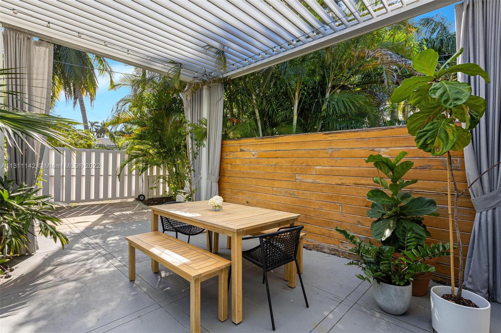 1314 Fillmore Street Hollywood, FL 33019 - Photo 35 of 47 a view of a patio with table and chairs potted plants with wooden floor and fence