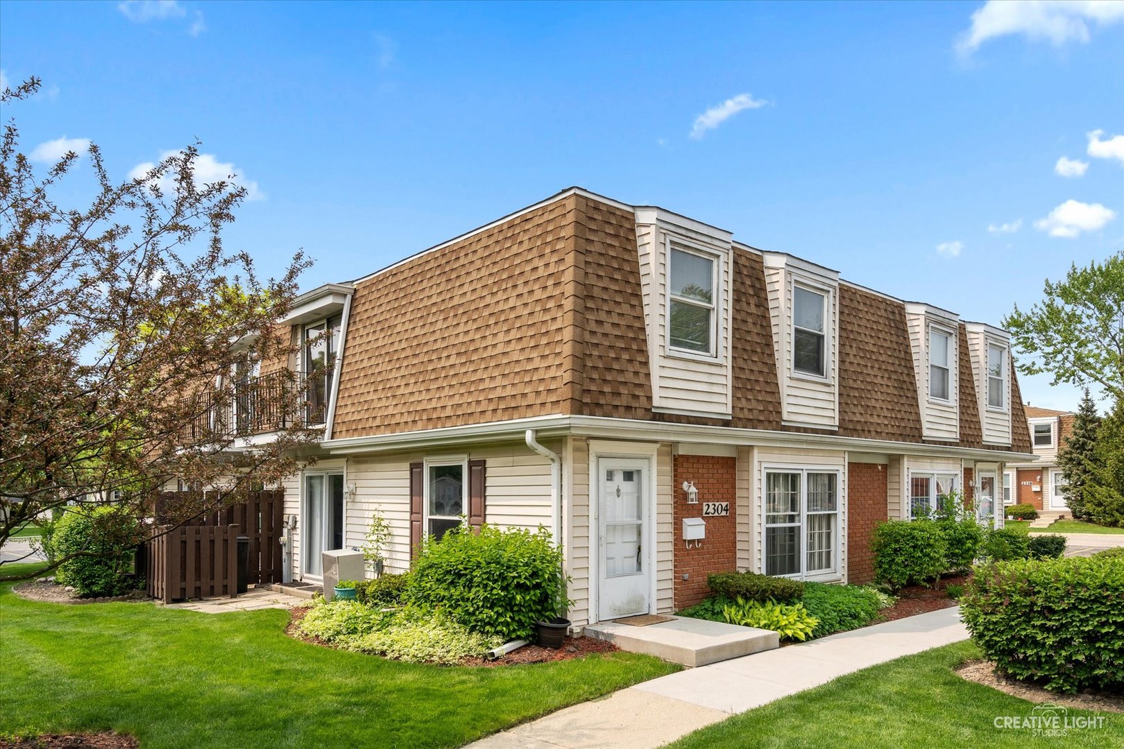 2304 Old Kings Court Streamwood, IL 60107 - Photo 1 of 22 a front view of a house with garden