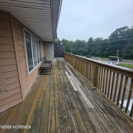 a view of balcony with wooden floor and fence