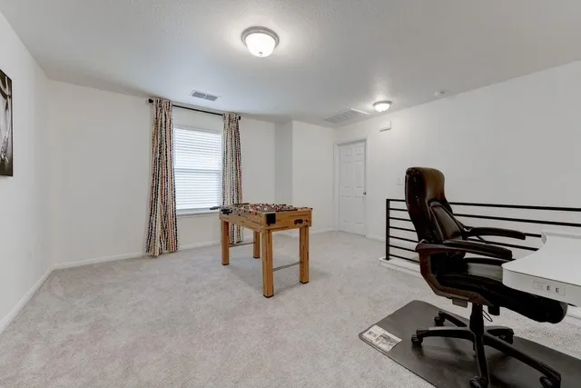 a view of a workspace with furniture and a window
