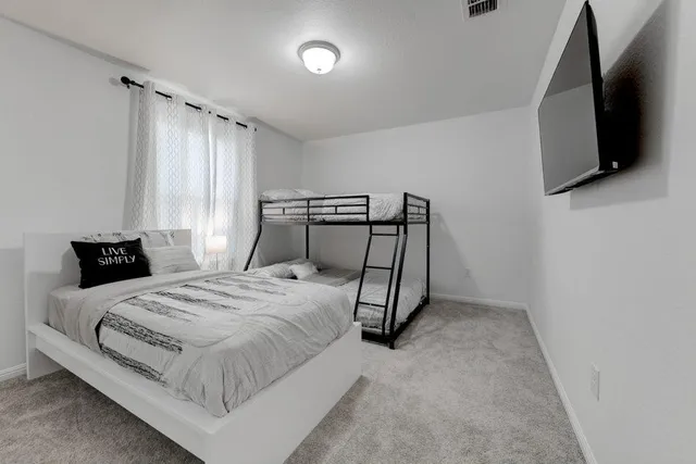 a bedroom with a bed and a flat screen tv