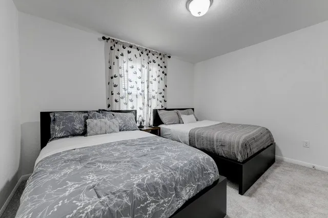 a bedroom with two beds and curtain