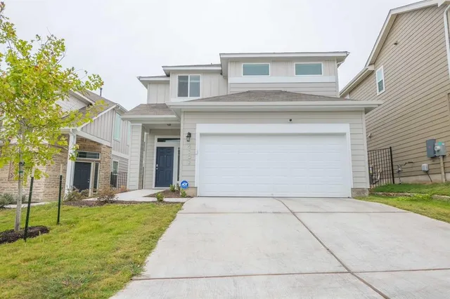 a front view of a house with a yard and potted plants