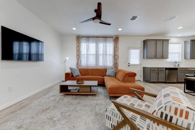 a living room with furniture ceiling fan and a window