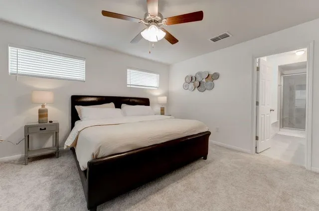 a bedroom with a bed and a ceiling fan