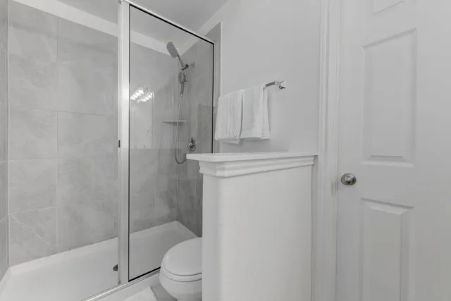 a bathroom with a shower a toilet and a shower