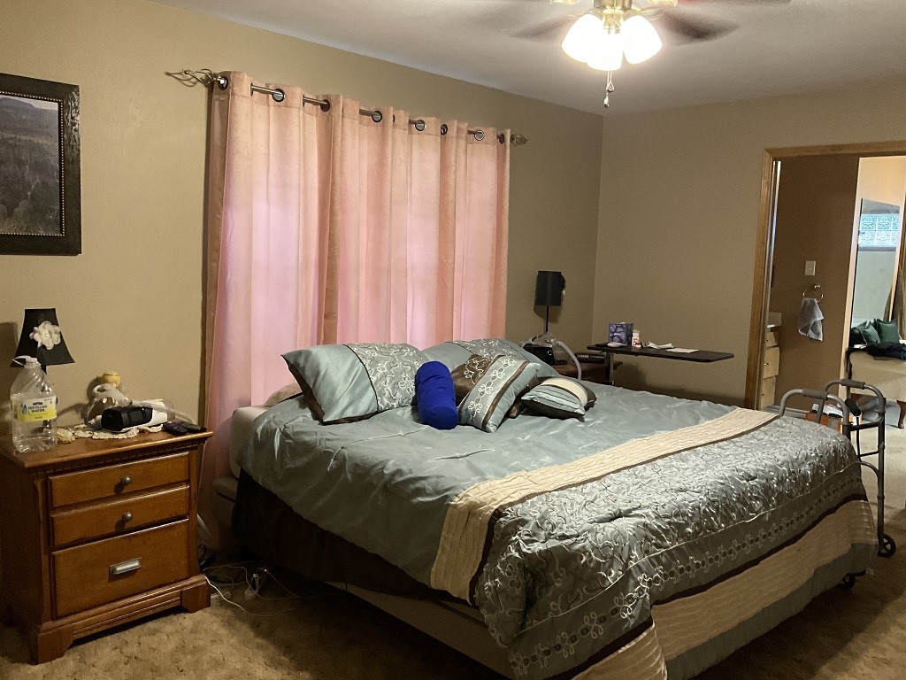 416 Division Street Jewett, TX 75846 - Photo 18 of 36 a bedroom with a bed and a chandelier