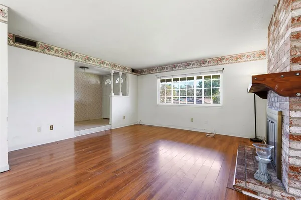 wooden floor in an empty room with a window