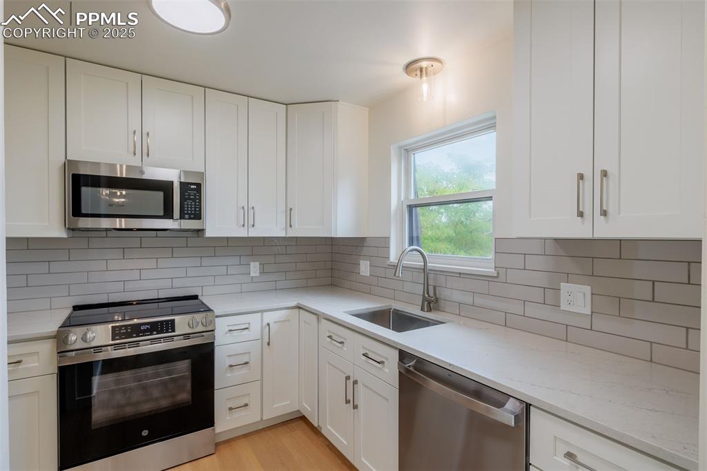 2905 Mesa Road, Unit D Colorado Springs, CO 80904 - Photo 13 of 34 a kitchen with cabinets stainless steel appliances a sink and a window