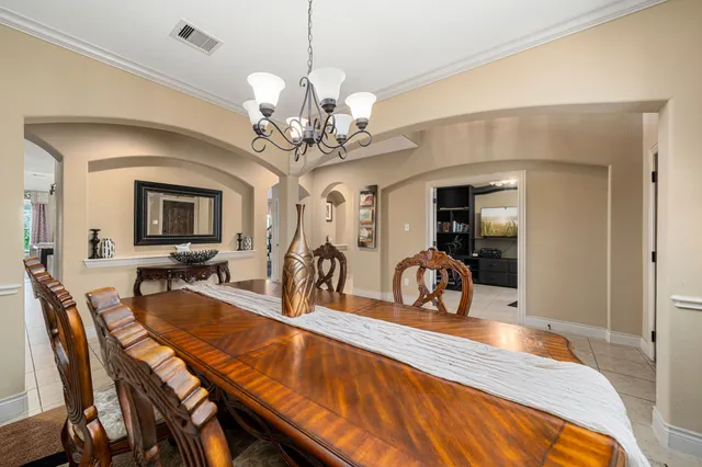 a view of a dining room with furniture a chandelier and wooden floor