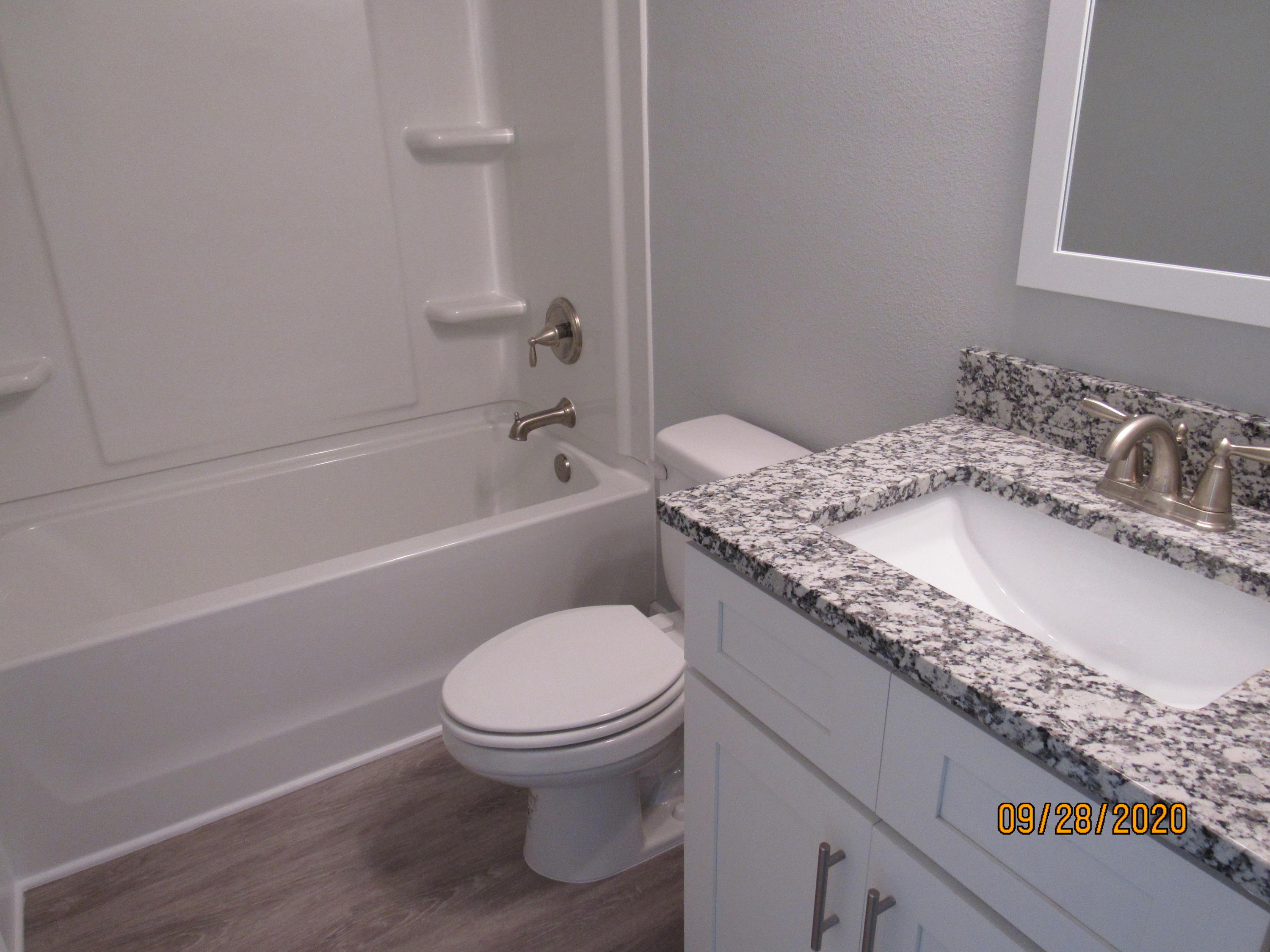 45 South Sand Palm Road Freeport, FL 32439 - Photo 13 of 19 a bathroom with a granite countertop toilet a sink and bathtub