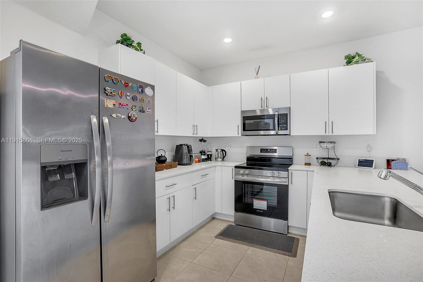 12859 Southwest 243rd Terrace Homestead, FL 33032 - Photo 5 of 38 a kitchen with granite countertop white cabinets and stainless steel appliances