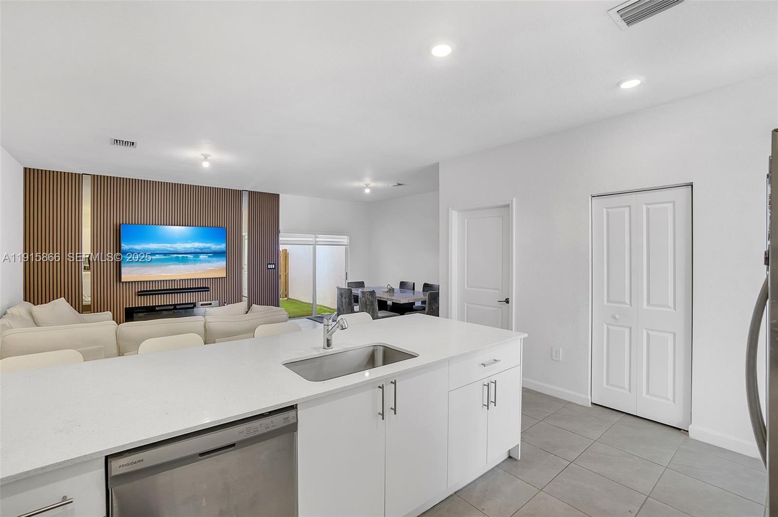 12859 Southwest 243rd Terrace Homestead, FL 33032 - Photo 7 of 38 a kitchen with stainless steel appliances a sink and a flat screen tv
