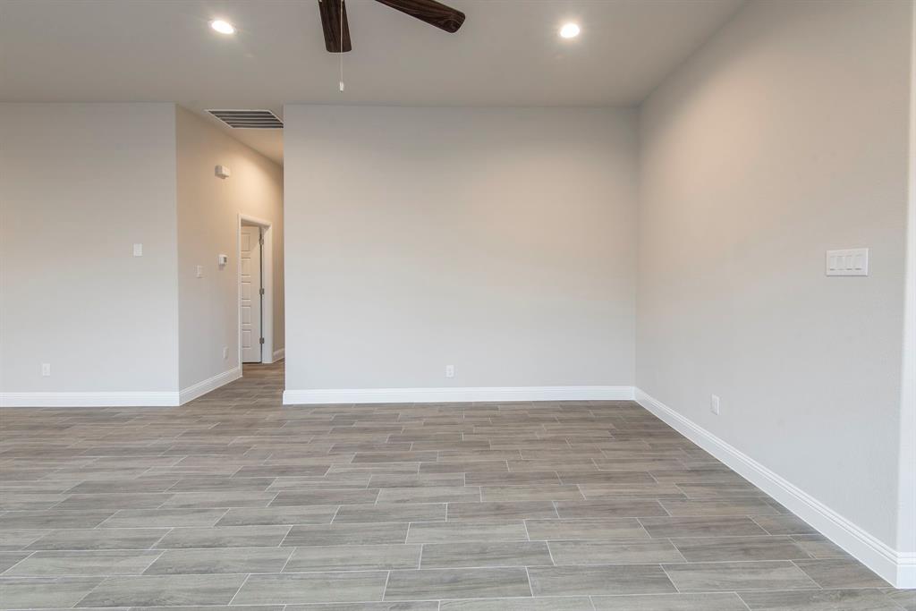 2301 Ruff Road Denton, TX 76205 - Photo 6 of 23 Spacious room featuring wood-look tile flooring, light gray walls, white baseboards, recessed lighting, and a ceiling fan with dark wood-finish blades