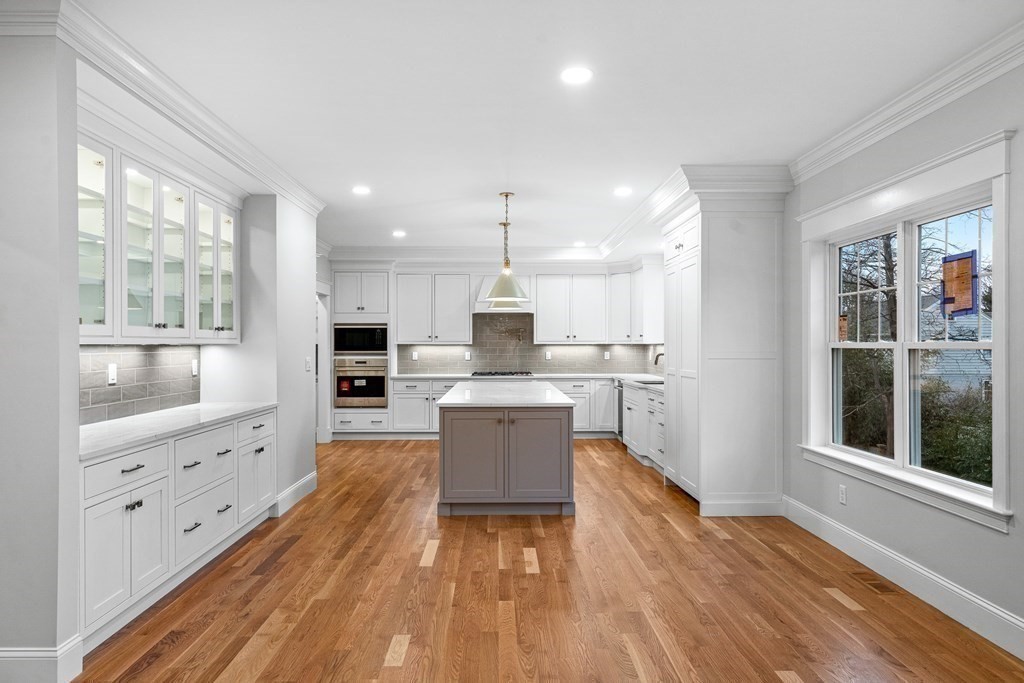 49 Allen Road Winchester, MA 01890 - Photo 14 of 38 a kitchen with wooden floors and white cabinets