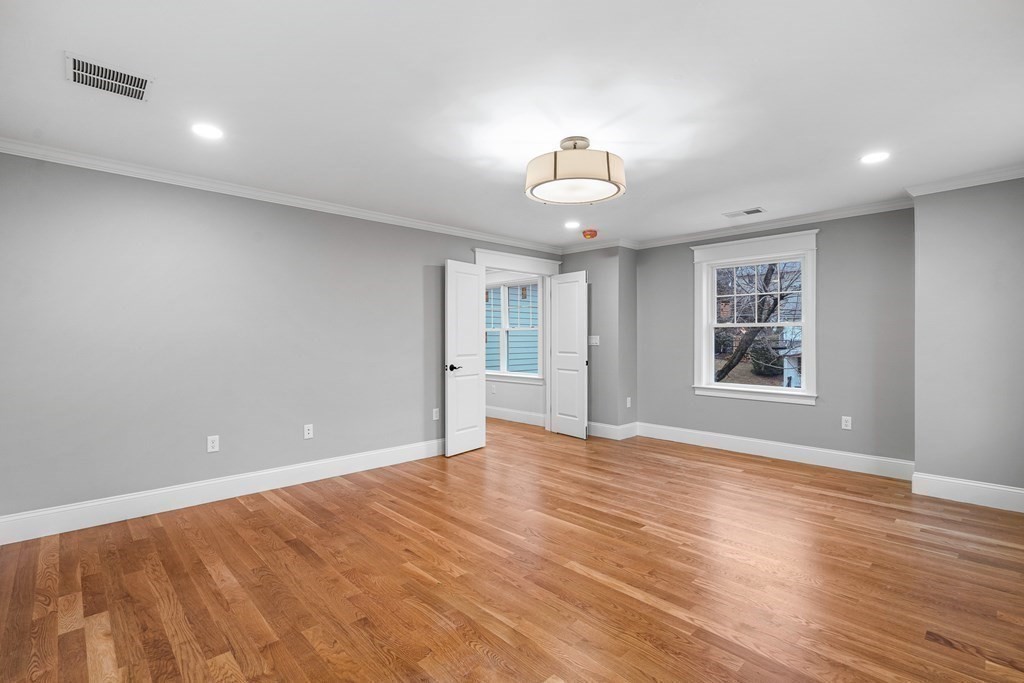 49 Allen Road Winchester, MA 01890 - Photo 22 of 38 a view of an empty room with a window and wooden floor