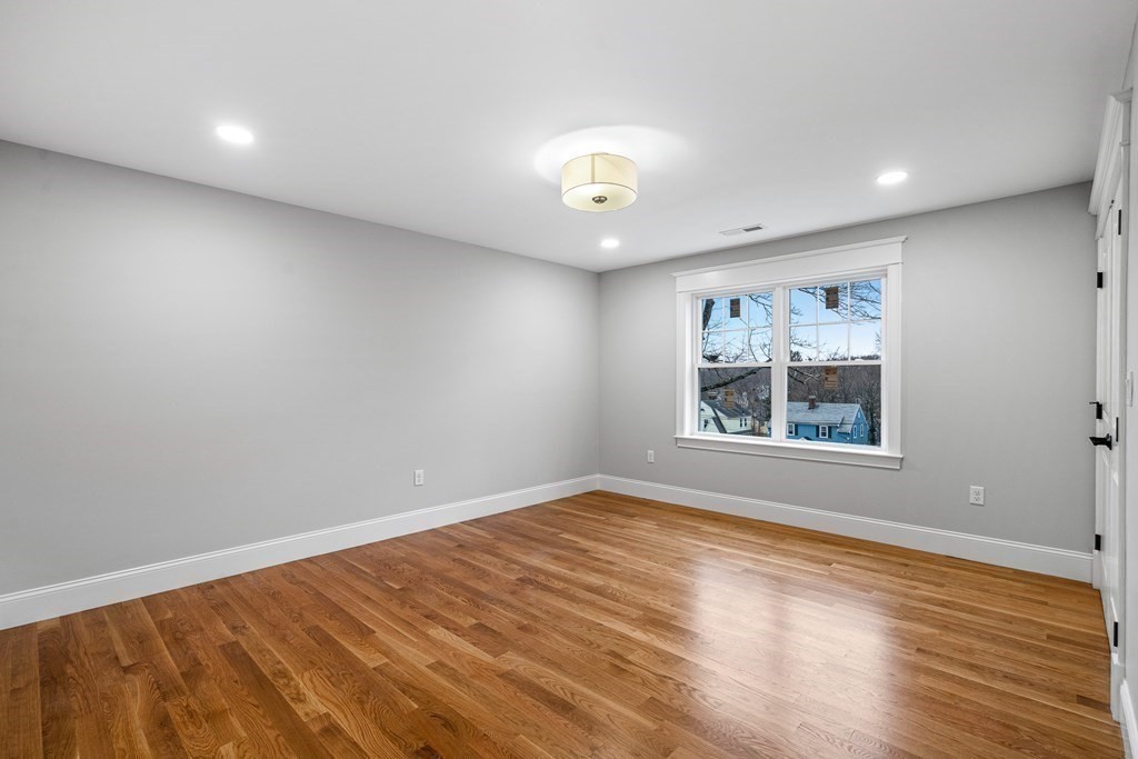 49 Allen Road Winchester, MA 01890 - Photo 28 of 38 an empty room with wooden floor and windows
