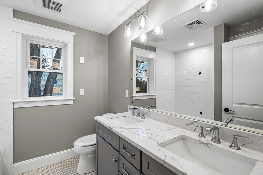 49 Allen Road Winchester, MA 01890 - Photo 29 of 38 a bathroom with a granite countertop sink a toilet and a mirror