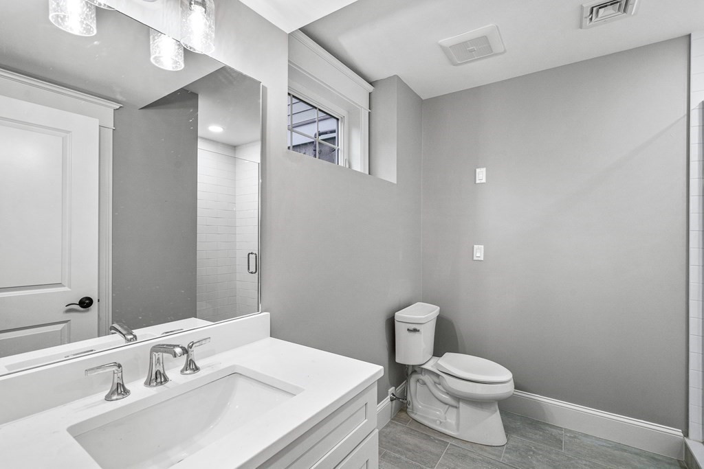 49 Allen Road Winchester, MA 01890 - Photo 37 of 38 a bathroom with a sink a toilet and mirror