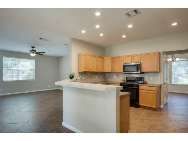 a view of an empty room with a ceiling fan and a window
