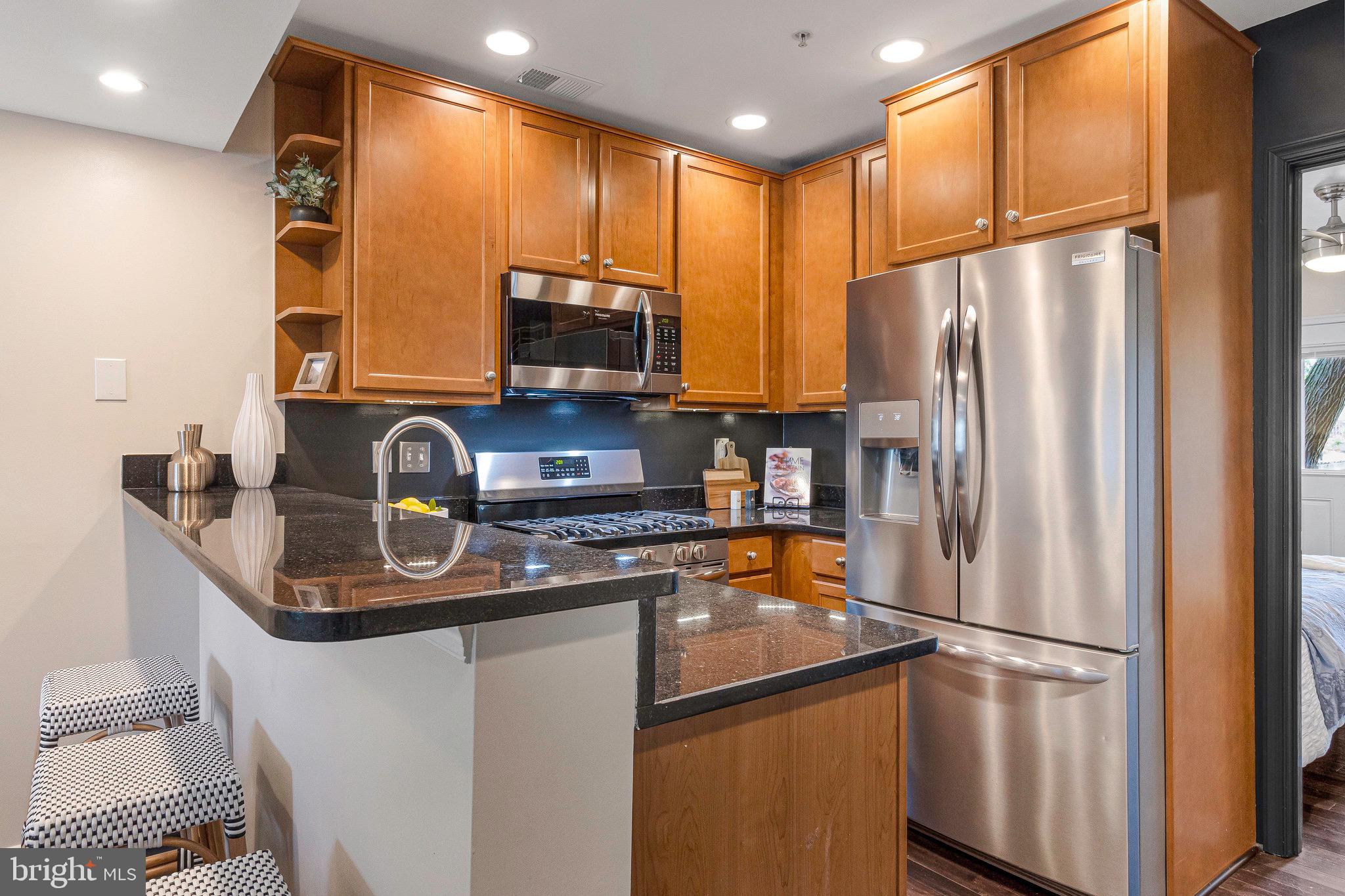 1519 Constitution Avenue Northeast, Unit 101 Washington, DC 20002 - Photo 8 of 32 a kitchen with stainless steel appliances granite countertop a refrigerator a stove a sink and a microwave