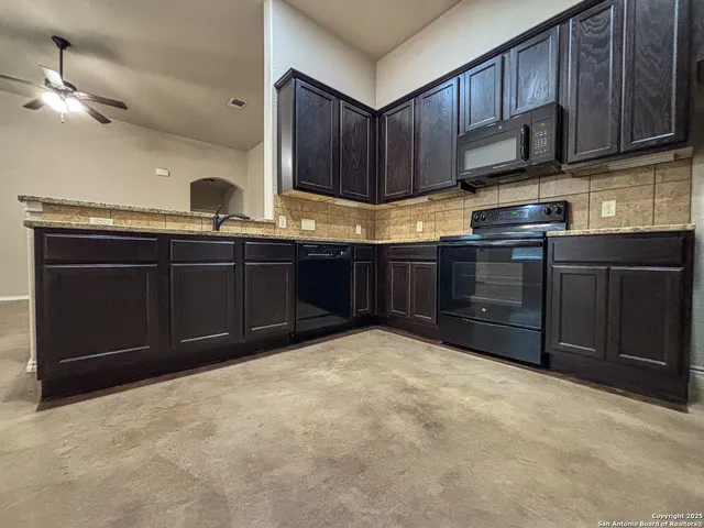 a kitchen with granite countertop a stove and cabinets